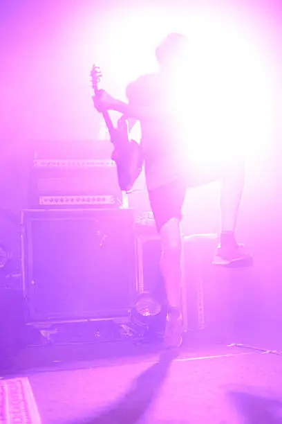 Photo of high jumping guitar on a stage