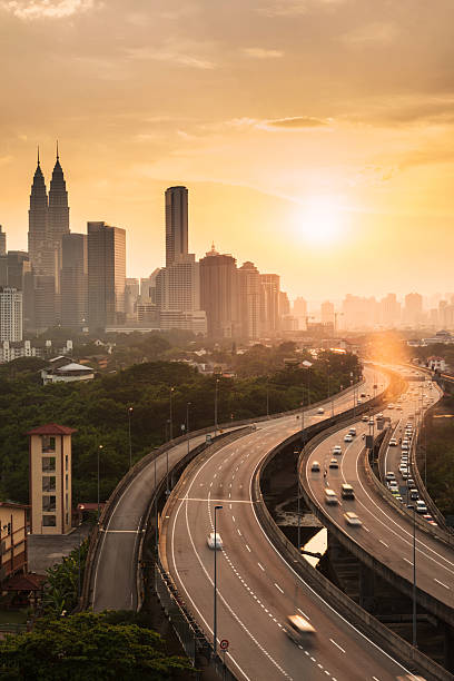 avec coucher de soleil de kuala lumpur - kuala lumpur skyline traffic sunset photos et images de collection