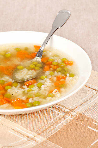 Chicken broth with vegetables Chicken broth - soup with carrots and peas, without meat. Decorated with parsley. Selective focus, shallow DOF. cooked selective focus vertical pasta stock pictures, royalty-free photos & images