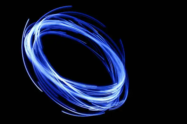 Photo of glowing circular blue, long exposure of creative light painting