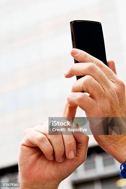 Masculino Mão Segurando O Telefone Inteligente Contra Céu - Fotografias de stock e mais imagens de A usar um telefone