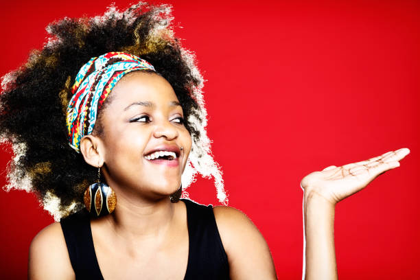 istock Afro-haired cutie looks at space she holds up 172480477