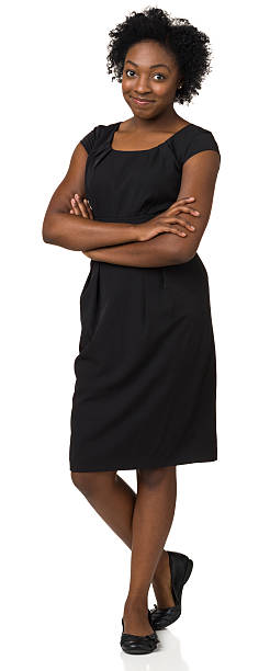 Satisfied Young Woman Standing, Arms and Legs Crossed Portrait of a young African-American woman on a white background. flat shoe stock pictures, royalty-free photos & images