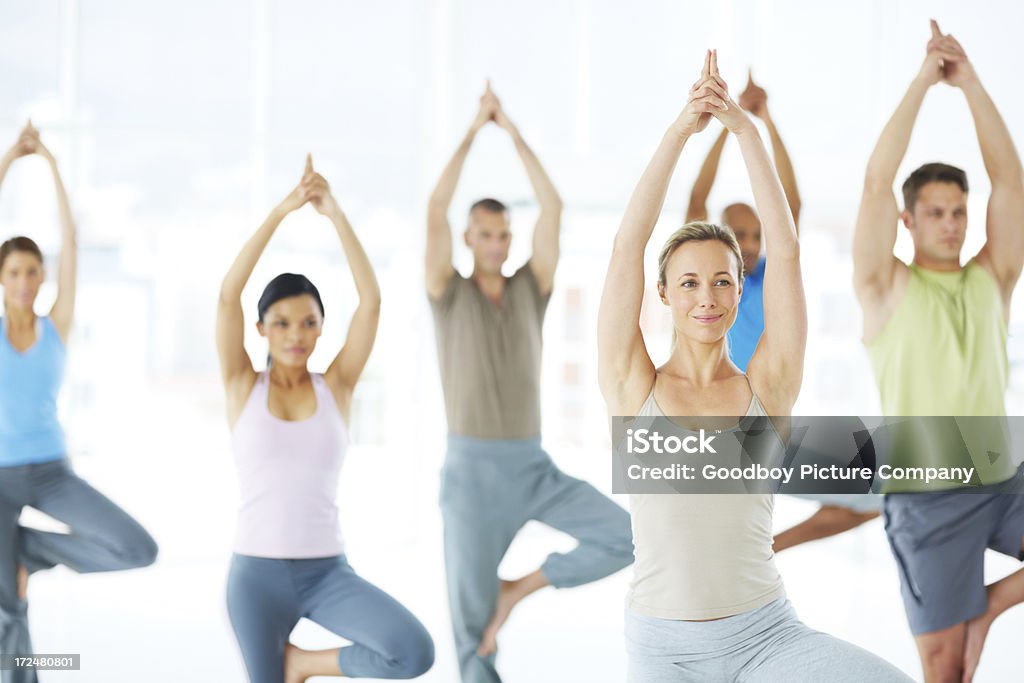 Tenant leurs postures - Photo de Cours de yoga libre de droits
