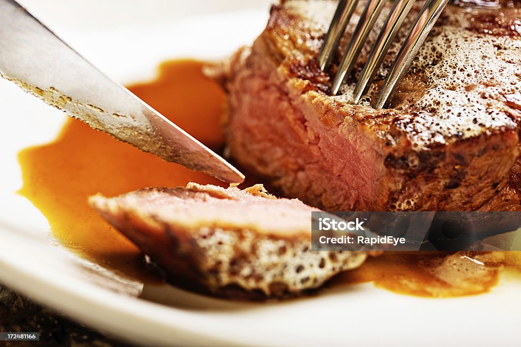 FATIANDO em Carne grelhada para revelar bife, médio raro interior - Foto de stock de Bife royalty-free