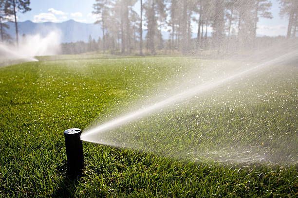 Watering a Golf Course With Sprinkler System stock photo