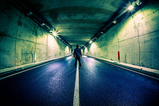 istock Man Standing in Middle of Underground Road Tunnel 172481595