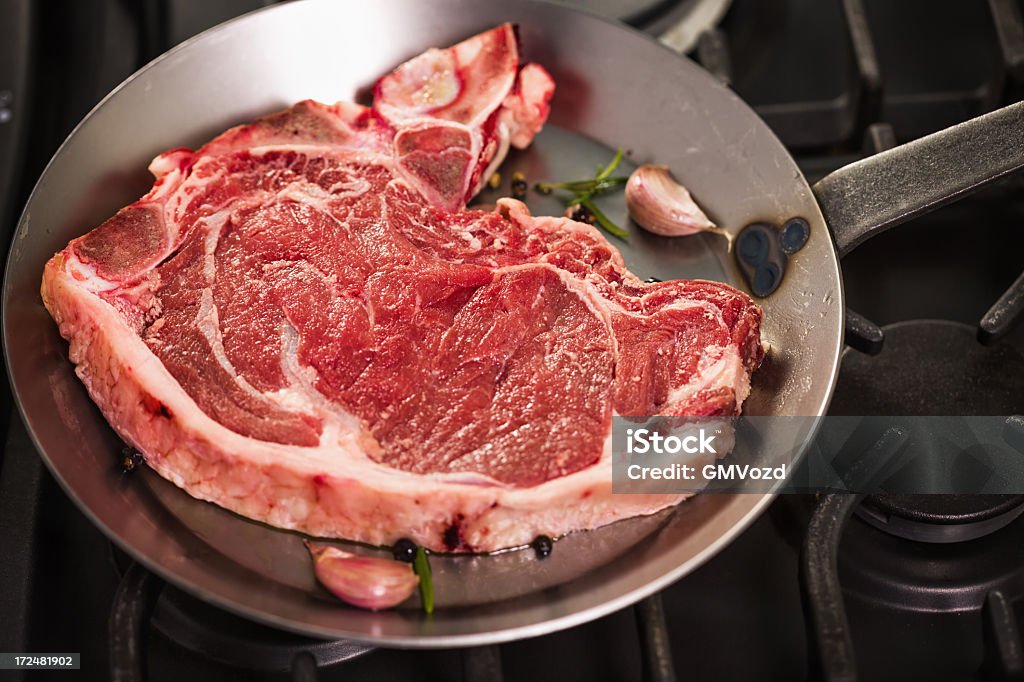 Raw Steak à l'os - Photo de Ail - Légume à bulbe libre de droits
