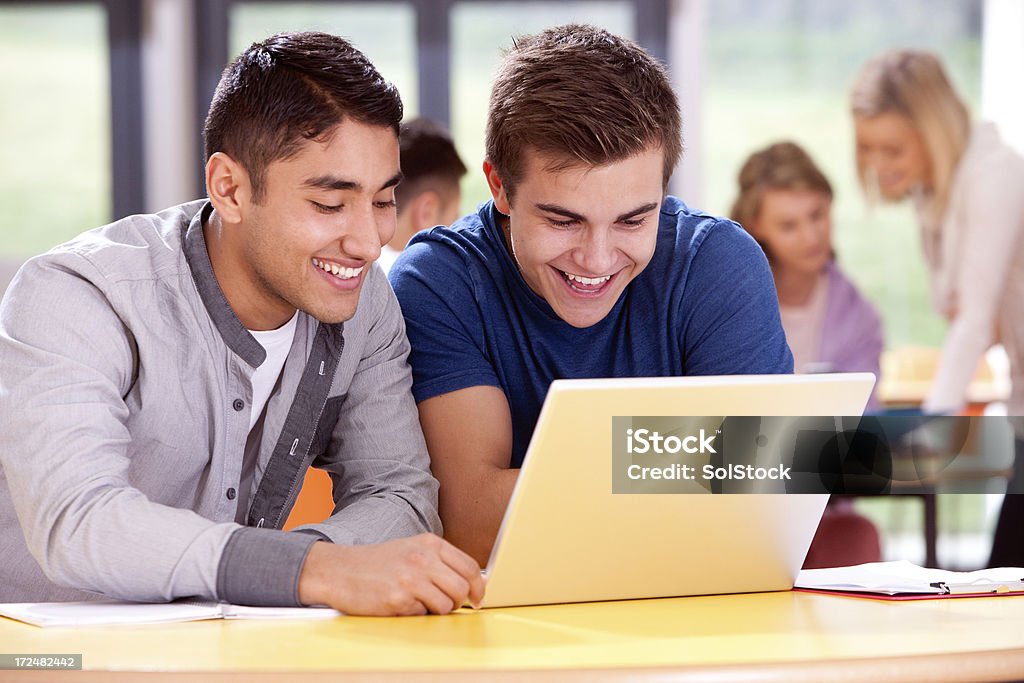 Teenagers using laptop Two teenage boys using a laptop. Adult Student Stock Photo