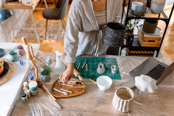 istock Woman sculpting clay with art pottery tools 1724830044