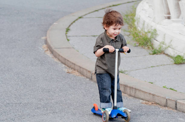 istock Cute little boy riding push scooter 172483995