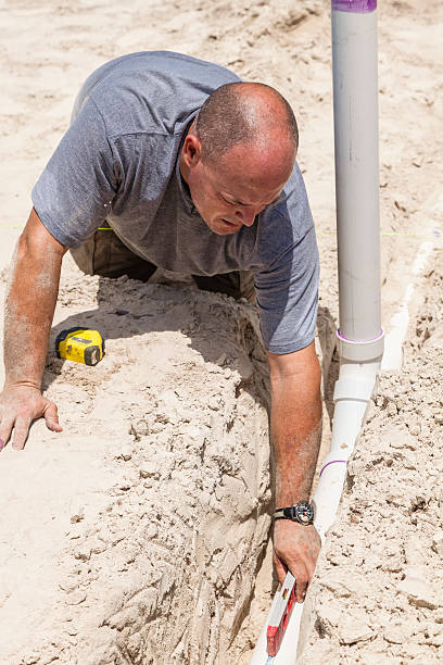istock Plumbing Specialist Check to Ensure Sewer Line is Level 172484292