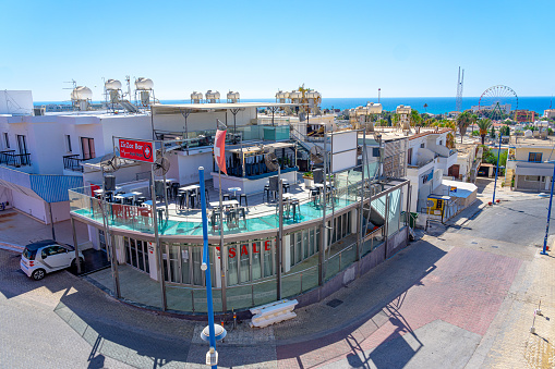 ZIC ZAC bar and nightclub in the free district of Ayia Napa, close to the Mediterranean Sea, Summer, September 2023. Daytime image. in the foreground hand holding earplugs to reduce noise.