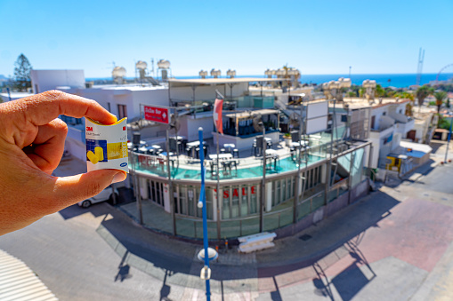 ZIC ZAC bar and nightclub in the free district of Ayia Napa, close to the Mediterranean Sea, Summer, September 2023. Daytime image. in the foreground hand holding earplugs to reduce noise.