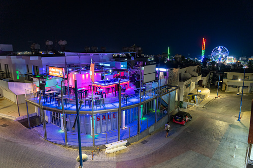 ZIC ZAC bar and nightclub in the free district of Ayia Napa, close to the Mediterranean Sea, Summer, September 2023. Daytime image. in the foreground hand holding earplugs to reduce noise.