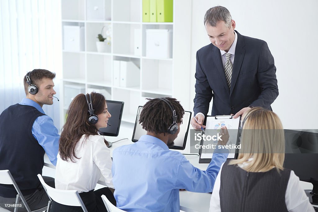Group of customer service representatives. "Executive manager showing charts to a group of customer service representatives while working. See more BUSINESS PEOPLE in OFFICE, CALL CENTER REPRESENTATIVES and ARCHITECTS with their PROJECT from this session. Click on images below for lightbox." 30-39 Years Stock Photo