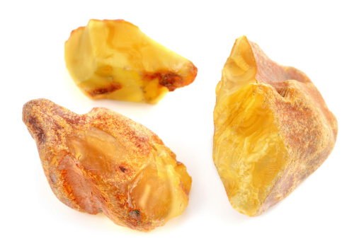 thee raw amber stones on white background