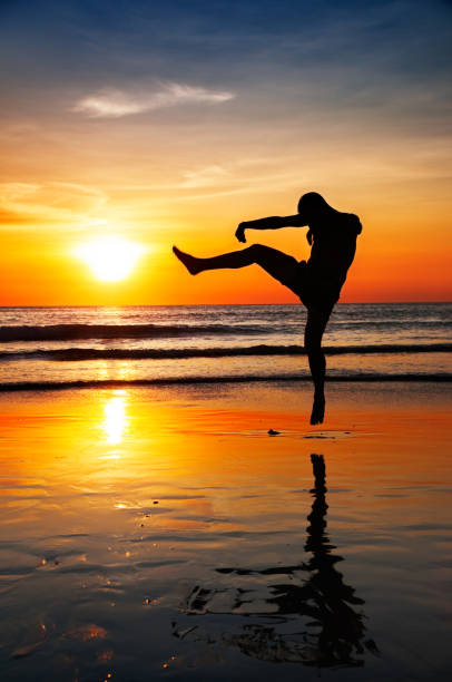 istock Young Man in Karate Jump on a Dark Seascape 172485414