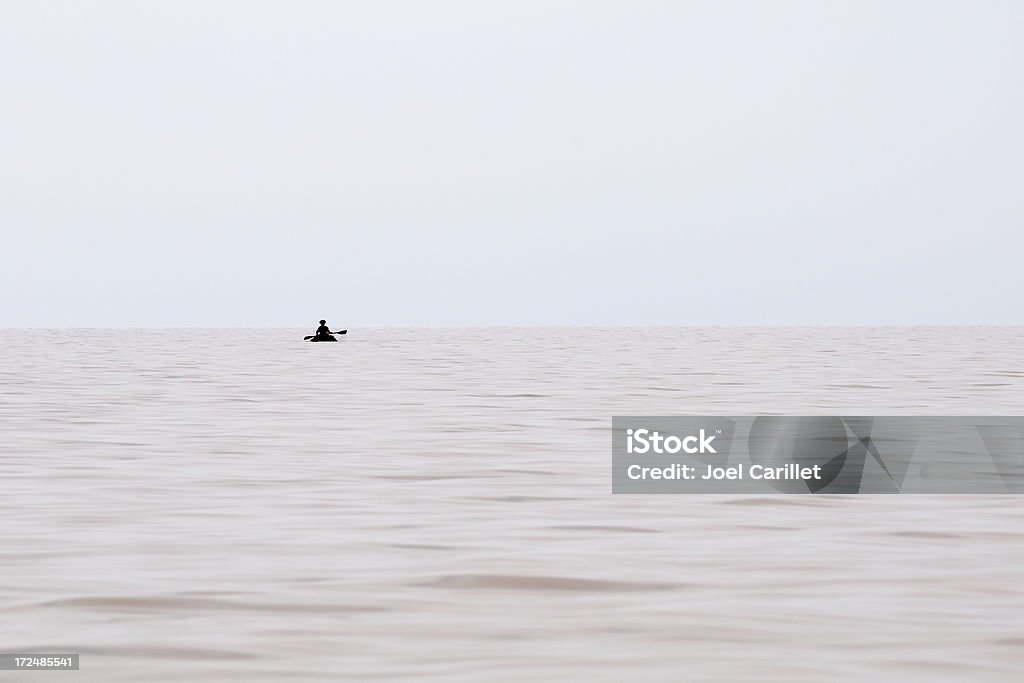 Silhoutte paddling on Lake Tana, Ethiopia A silhouetted figure paddling on a large lake. Location is Lake Tana, Ethiopia Separation Stock Photo