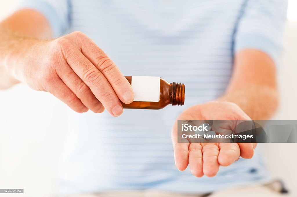 Mani di un uomo rimozione di compresse dal flacone - Foto stock royalty-free di 60-69 anni