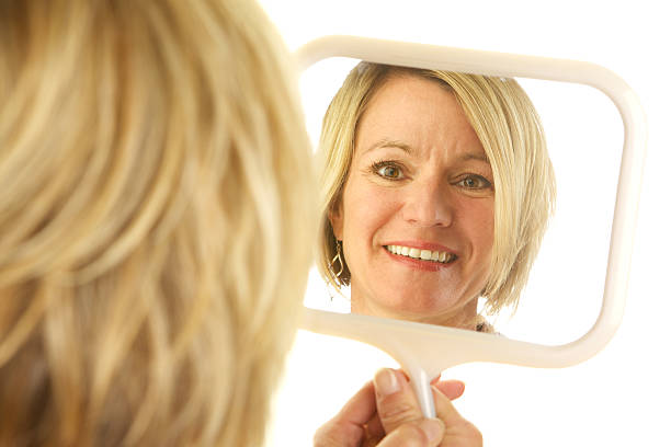 istock Blond Woman Looking at Her Reflection in a Mirror 172486469