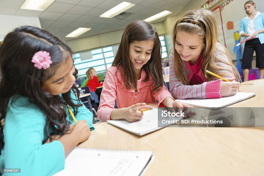 Linda Criança de escola fundamental meninas estudando juntos em sala de aula de Escola pública - Foto de stock de Aluna royalty-free