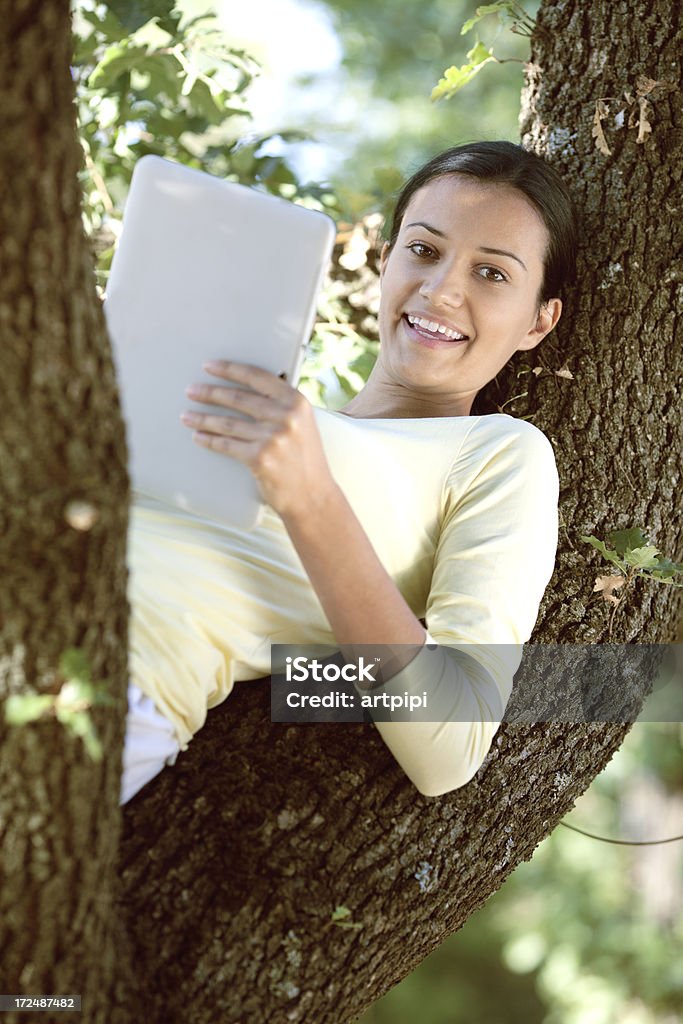 Jovem mulher trabalhando em tablet ao ar livre - Foto de stock de 20 Anos royalty-free