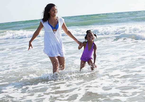 istock Mother and daughter walking in the surf 172487531