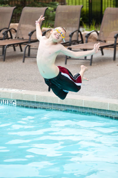 istock Young Boy Jumping into a Swimming Pool 172488381