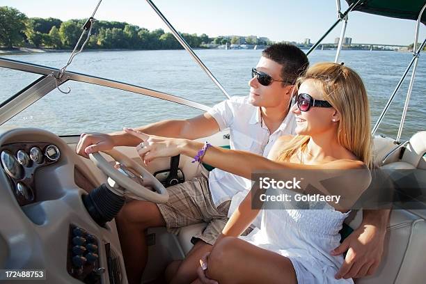 A Young Couple Riding On A Boat In The Ocean Stock Photo - Download Image Now - Couple - Relationship, Driving, Sailing