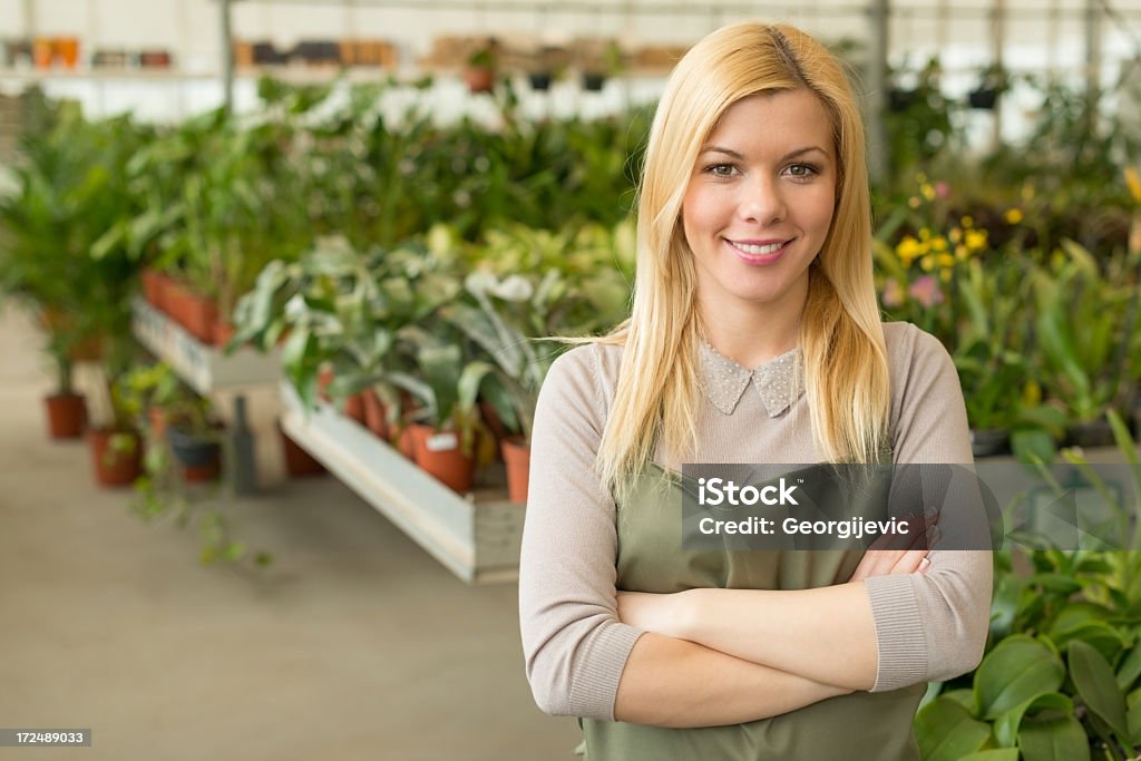 Giovane sorridente donna giardiniere - Foto stock royalty-free di Adulto