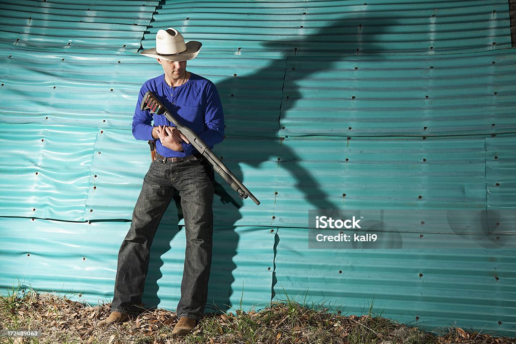 Hombre que agarra de escopeta - Foto de stock de Escopeta libre de derechos