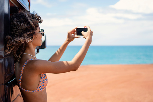 Young woman making selfie on beautiful beach