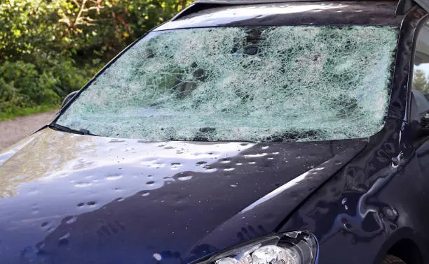 Photo of Hail damage to a car. Large hailstones have completely destroyed a car