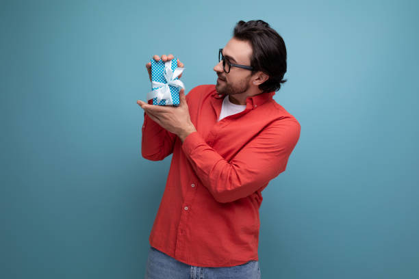 istock joyful cute young guy with chic black hair received a gift 1724995797