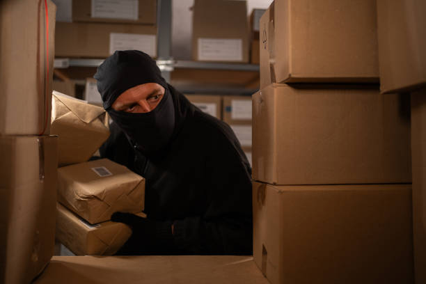 istock A thief stealing boxes in a warehouse at night in the dark. Warehouse and store security concept 1725057766