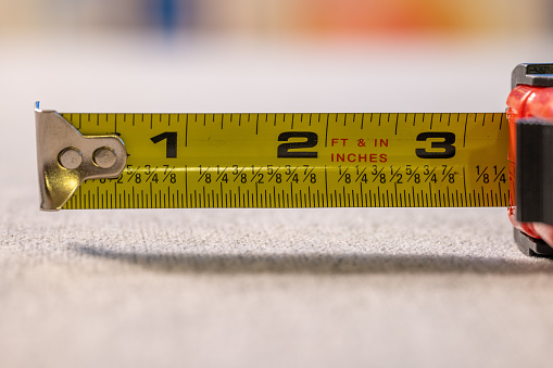 Close-up of a blue rolled up tape measure. Shallow depth of field, space for copy.