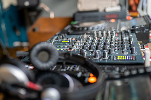DJ console. Amplifying equipment, studio audio mixer knobs and faders. Workplace of sound engineer. Close up, remote control for adjusting sound, audio mixer. Music production, creation.
