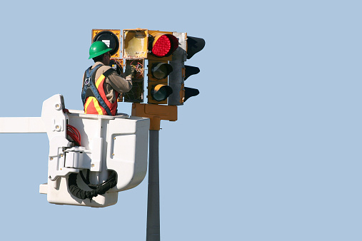 Traffic light technician repairs a defective assembly.