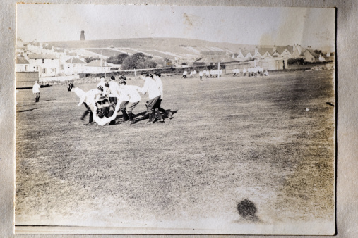 Vintage photograph from the late Victorian period showing a group of schoolboys playing rugby football.