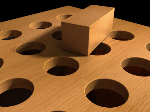 A square peg on a wooden board with round holes. 3D render with HDRI lighting and raytraced textures.