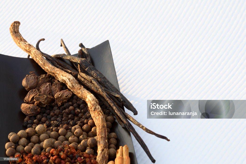 Brown spices. diverse spices on a black bowl wood over white paper. Alternative Medicine Stock Photo