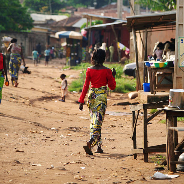 St. Louis. Senegal. October 10, 2021. An African woman in national clothes walks along the street of a seaside town on the Atlantic Ocean.