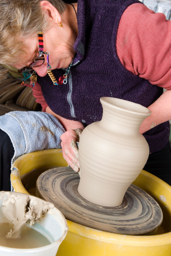 Woman at a potter's wheel making a beautiful vase. 
