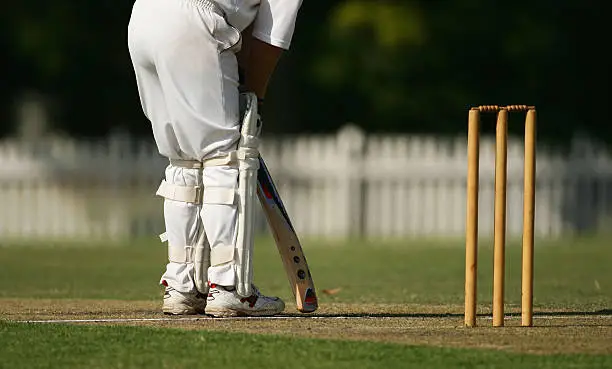 A cricket batsman faces up at the crease