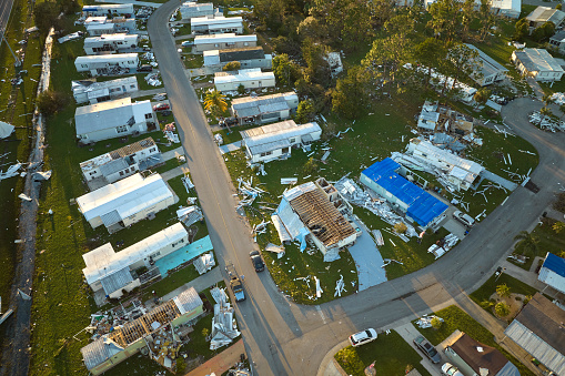 Severely damaged by hurricane Ian houses in Florida mobile home residential area. Consequences of natural disaster.