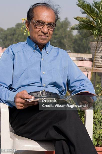 Jeden Radosny Starszych Mężczyzn Indyjski Człowiek Pionowe Siedzi Czytanie Na Zewnątrz - zdjęcia stockowe i więcej obrazów Bangladesz