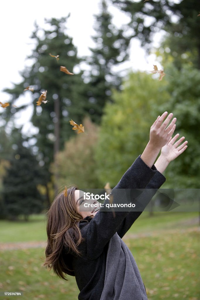 Belle souriante jeune femme jeter feuilles d'automne, espace pour copie - Photo de Jeunes filles libre de droits