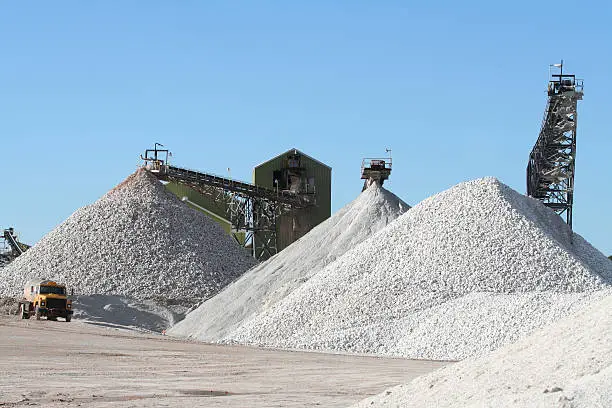 Piles of gypsum being processed at a plant. Raw material used for fabricating wallboard in the construction industry.
