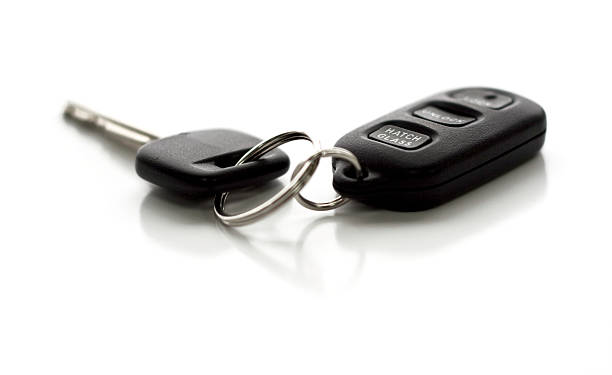 Remote control entry and car key ring on white background A car key with remote control. Functions include Lock, Unlock, and Hatch Glass. Narrow depth of field with focus on closest portion of key and remote. Isolated on white background. car key stock pictures, royalty-free photos & images